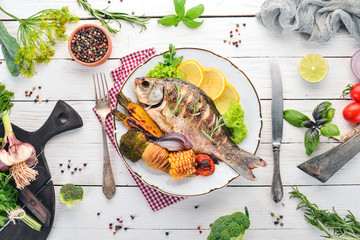 Baked fish carp. On a wooden background. Top view. Copy space.