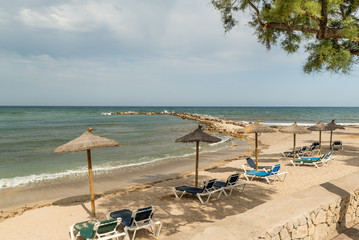 strandliegen direkt am Meer  mit Sonnenschirm