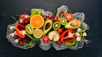 Healthy food. Vegetables and fruits On a black wooden background. Top view. Copy space.