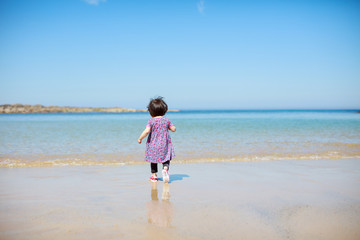 Fototapeta na wymiar baby girl playing at summer beach