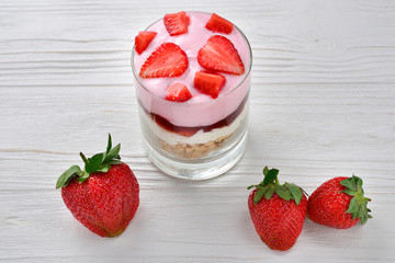 Home made granola breakfast with strawberries and plain yogurt, served in the glass.