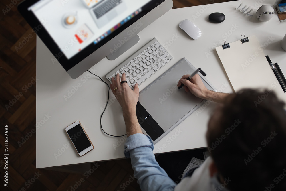 Aufkleber young male designer using graphics tablet while working with com