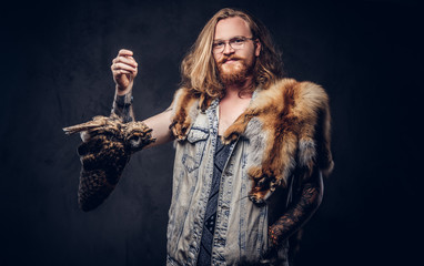 Portrait of a tattoed redhead hipster male with the fox skin