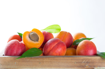 Fresh apricots on a white wooden background.