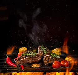 Zelfklevend Fotobehang Beef steaks on the grill with flames © Lukas Gojda