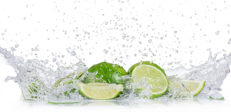 Fresh limes with water splash over white background.