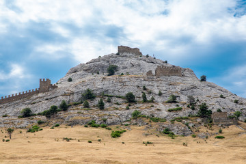 stone mountain with a fortress against the sky