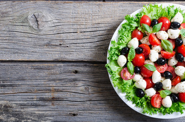 Salad with basil , tomatoes , olives and mozzarella