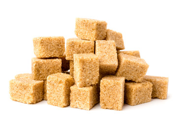 A pile of cane unrefined sugar on a white background, close-up.
