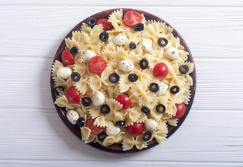 Pasta salad with mozzarella , olives and tomatoes
