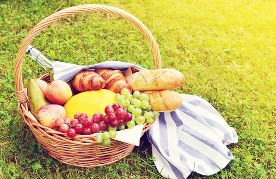Basket with Food Fruit Bakery Cheese Ham Tomato Picnic Green Grass Summer Time Rest Background Toned Photo