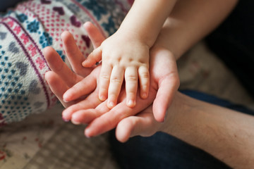 Family concept.Three hands of the family - baby, mother and father. Unity, protection and happiness. Focus on infant handle