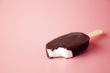chocolate ice cream bite and crumbled on a pink background. summ