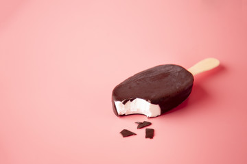 chocolate ice cream bite and crumbled on a pink background. summ