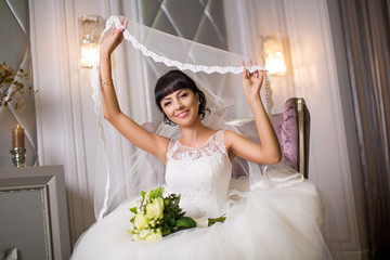 Happy bride in wedding dress hold bridal veil over your head