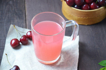 Kissel with cherries in a glass on an old wooden background, traditional russia or poland drink, berry jelly, mousse, summer pink drink,