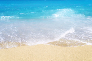 Top view of sandy beach with blue turquoise water and waves. Summer and holiday.
