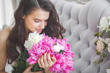 Very beautiful woman with flowers and gift indoors