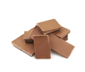 Pile of milk chocolate pieces isolated