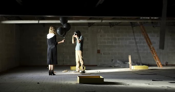 Floaty sliding dolly wide shot of photographer looking through camera at model 