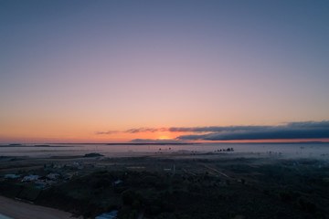 amanecer en ituzaingo corrientes desde drone con reflejos de la luz en la niebla