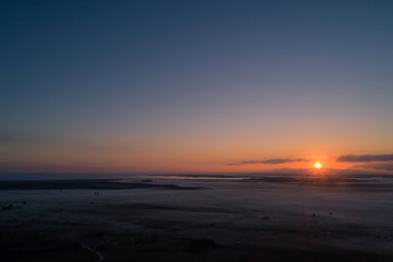 Fototapeta na wymiar amanecer en ituzaingo corrientes desde drone con reflejos de la luz en la niebla