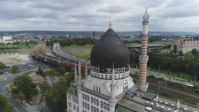 Static drone shot of dome and minaret of large mosque in Dresden, cargo train and skyline in the background, Islam religion in Germany, Europe
