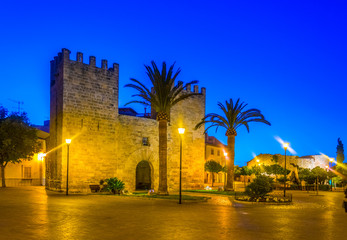 Sunset view of Porta del moll leading to the old town of Alcudia, Mallorca, Spain