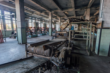 Abandoned tea factory with remnant of rusty equipment. Broken conveyor belt