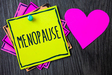 Handwriting text writing Menopause. Concept meaning Cessation of menstruation Older women hormonal changes period Border sticky remember cards love heart pinned dark woody background.