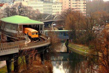 Just another day in Berlin, Germany. A yellow U-bahn train exits the platform, transporting people...