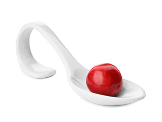 Spoon with sweet red cherry on white background