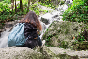 Beautiful asian woman taking a photo around mountains near the river at spring time with camera