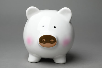 Cute white piggy bank on gray background