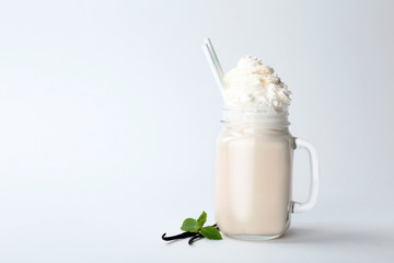 Mason jar with delicious milk shake on white background