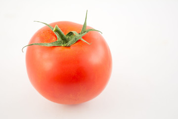 one unpeeled, fresh, red tomato with green tail on white background