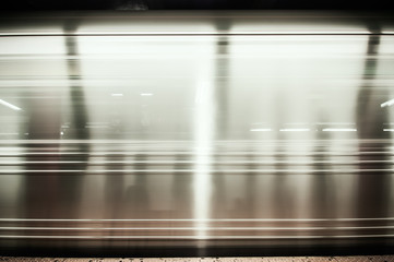 A fast moving subway car passing by a station in New York City