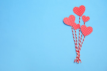 Composition with small paper hearts on color background