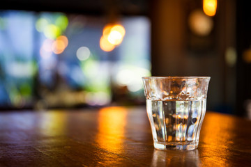 Mineral water in glass bottle left on the wooden table, concept of healthy food and drink.