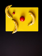 expresión hecha con frutas en un fondo negro - obrazy, fototapety, plakaty