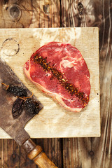 chipotle flakes chilli spice  with bbq raw beef steak on wooden board