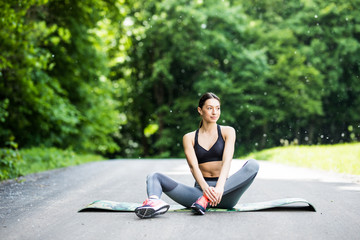 Woman performs stretching before sport in park outdoors