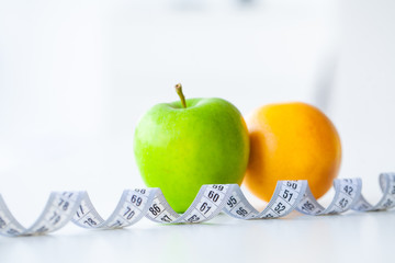 Diet. Fitness and healthy food diet concept. Balanced diet with vegetables. Fresh green vegetables, measuring tape on white background. Closeup