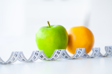 Diet. Fitness and healthy food diet concept. Balanced diet with fruit. Fresh fruit, measuring tape on white background. Closeup