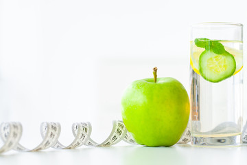 Diet. Fitness and healthy food diet concept. Balanced diet with fruit. Fresh fruit, and glass water, measuring tape on white background. Closeup