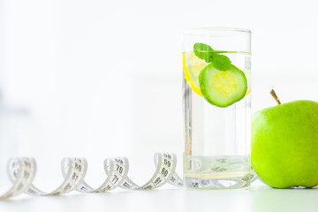 Diet. Fitness and healthy food diet concept. Balanced diet with fruit. Fresh fruit, and glass water, measuring tape on white background. Closeup