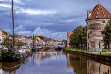 Canal view in a Dutch city with an old defence wall and tower just after rainfall