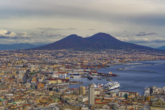 Panoramic city view over Seaport of Napoli with ships and Mount Vesuvius volcano, seen from Sant Elmo castle, Naples, Campania