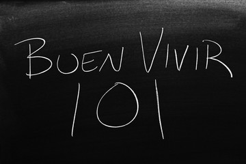 The words Buen Vivir 101 on a blackboard in chalk.  Translation: Living Well 101