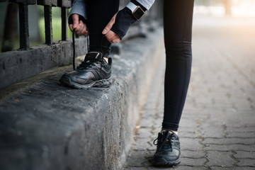 Sport runner woman tying laces before training. Marathon.
